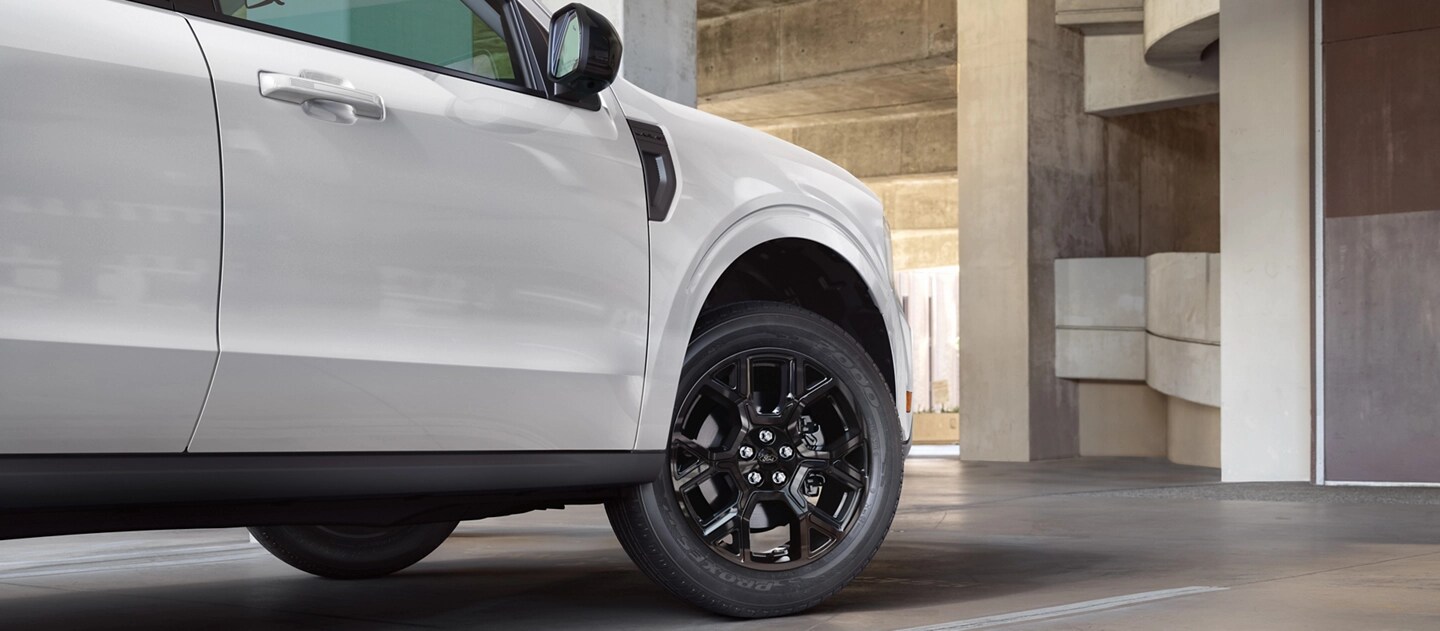 A 2025 Ford Maverick® pickup parked in front of a modern concrete structure
