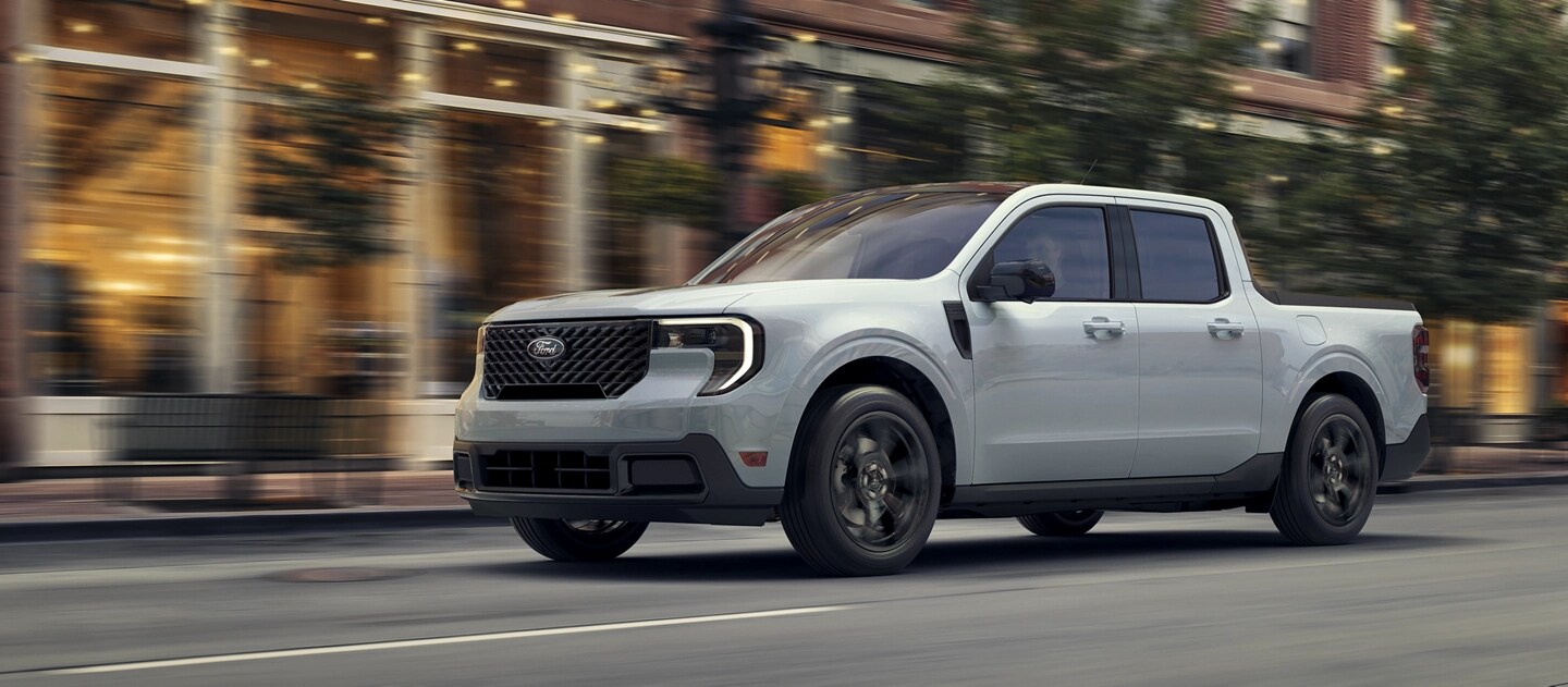 A 2025 Ford Maverick® pickup with Black Appearance Package driving on a city street in the evening