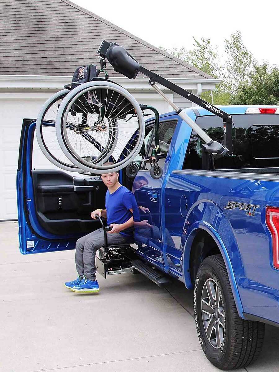 A blue F-150 with a wheelchair hoist in the bed