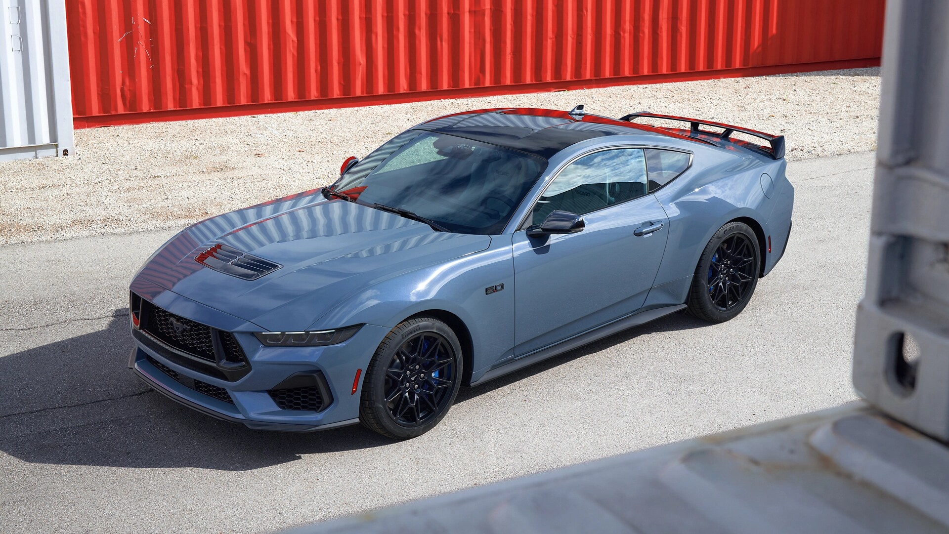 2025 Ford Mustang® GT coupe with Mustang Nite Pony Package parked near shipping containers