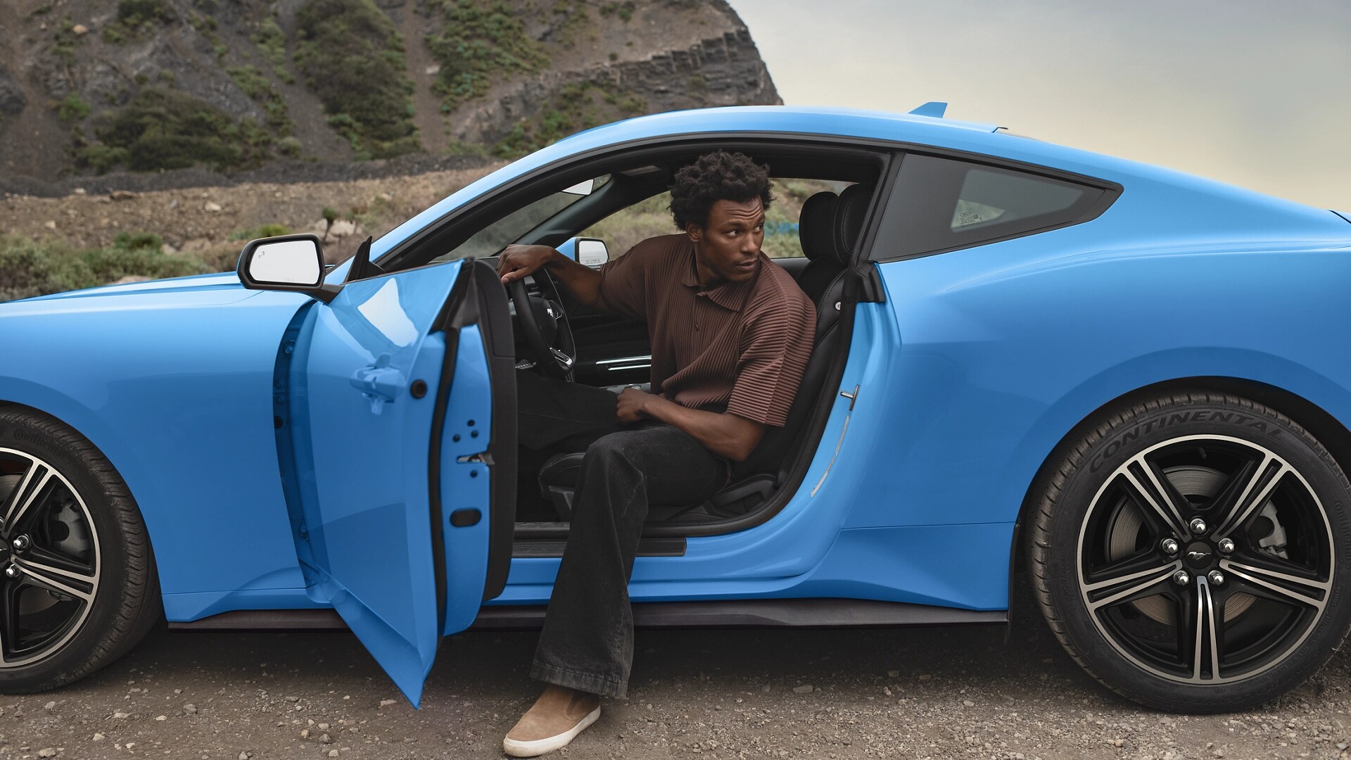Person exiting a 2025 Ford Mustang® coupe parked in the desert