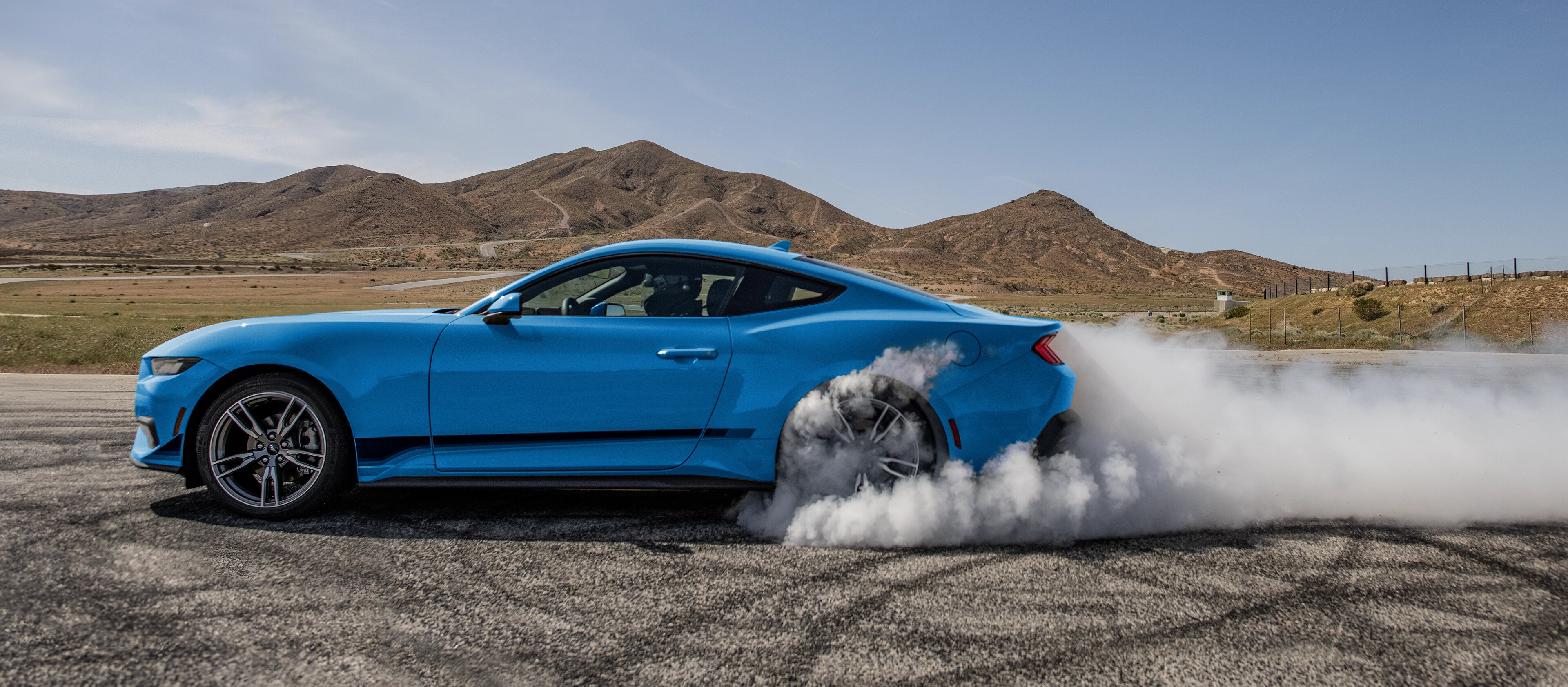 2025 Ford Mustang® EcoBoost® coupe in with a driver doing burnouts on a closed course