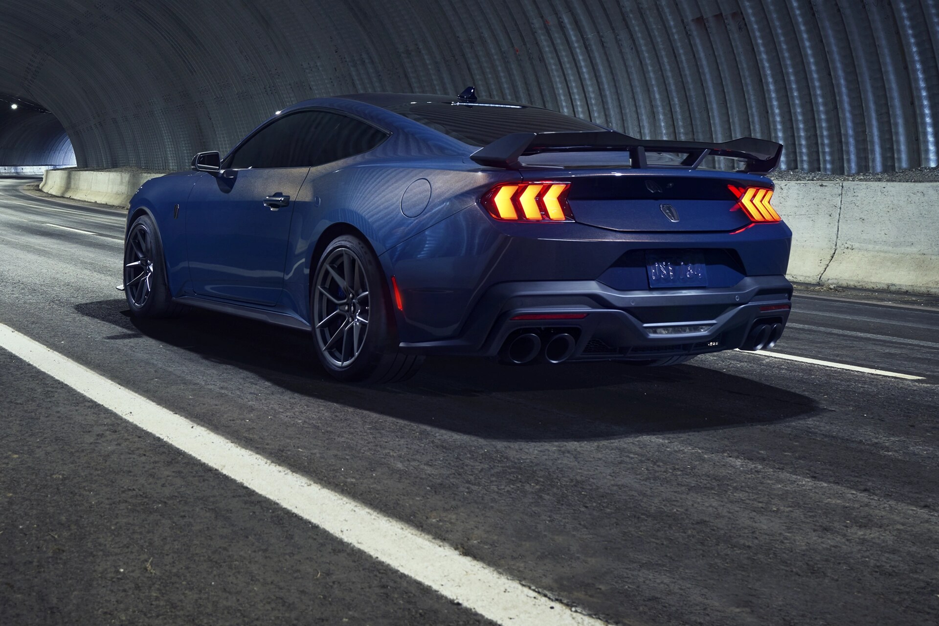 2025 Ford Mustang® Dark Horse™ coupe in available Blue Ember Metallic being driven in a tunnel