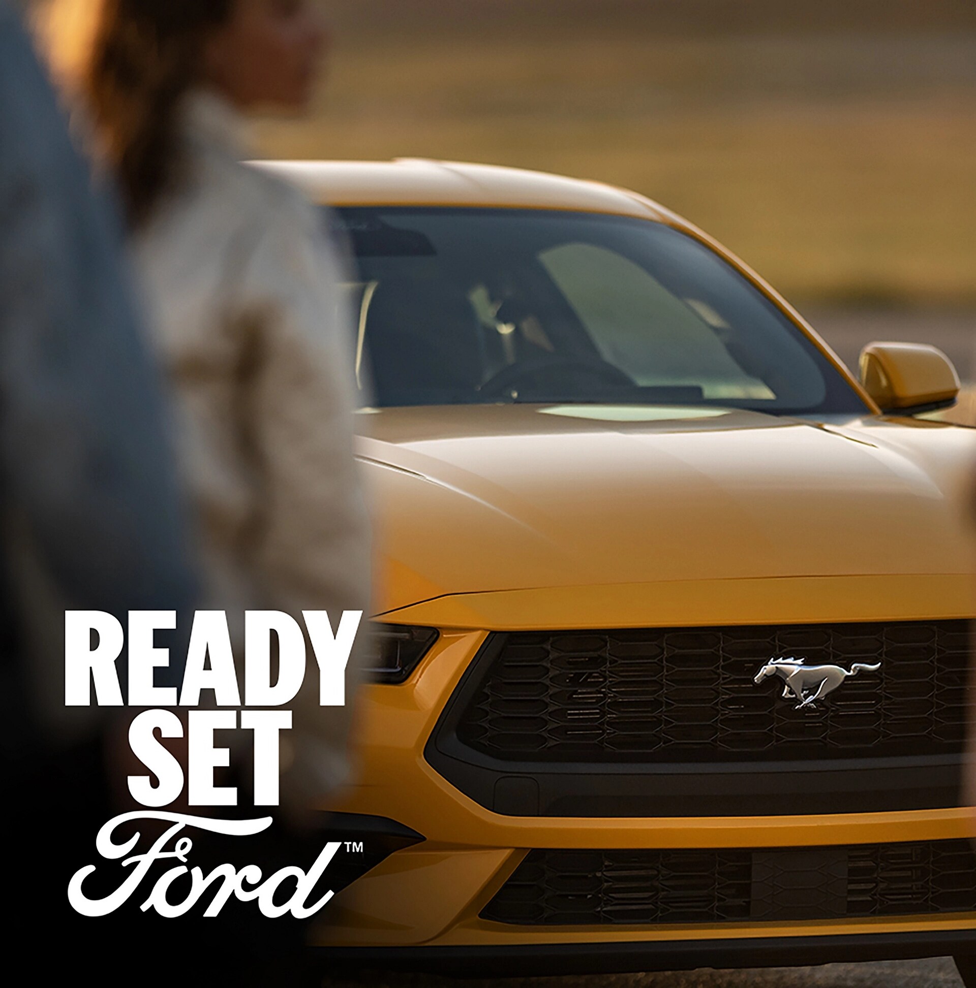 Yellow 2026 Ford Mustang® GR Premium Coupe parked with a woman in the foreground