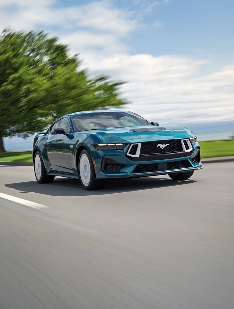A 2026 Ford Mustang® GT Premium with the available FX Package being driven near a lake