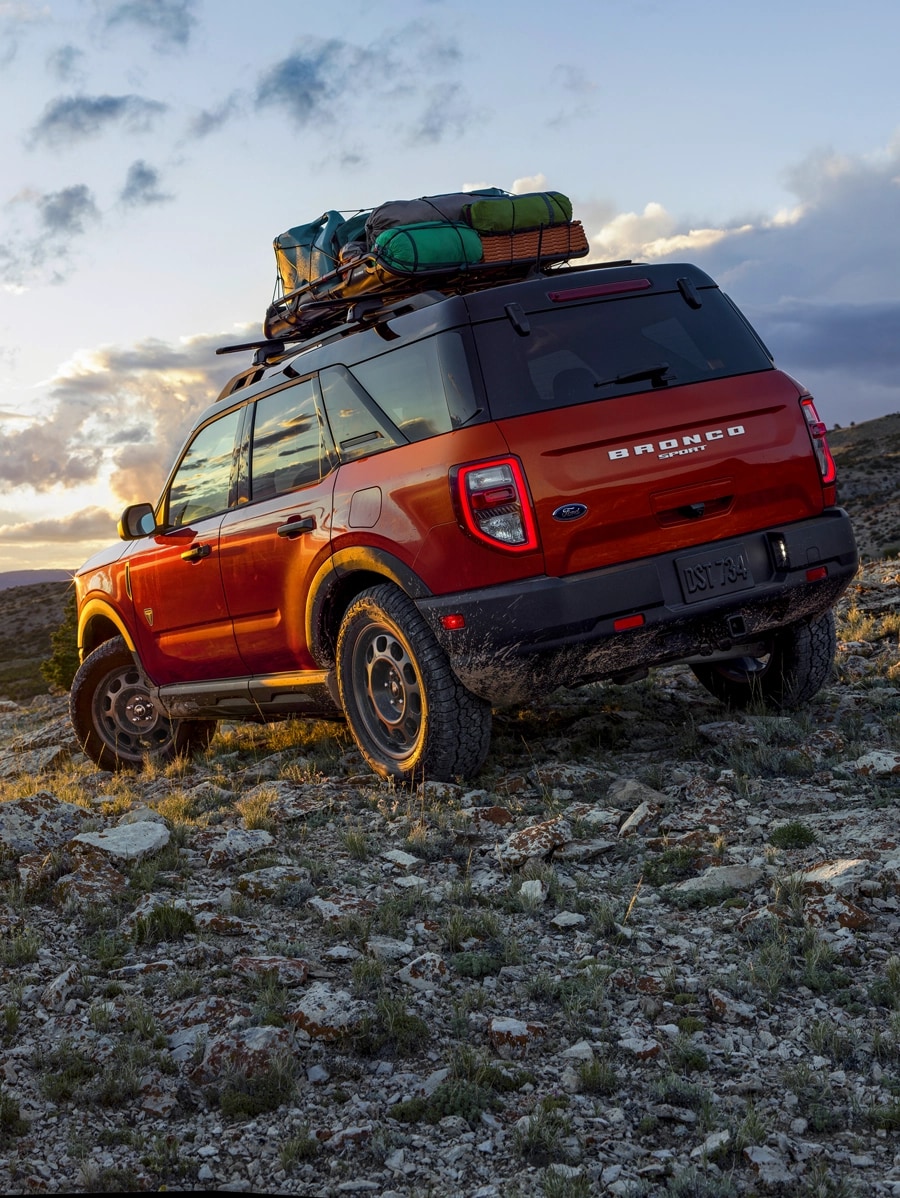 Bronco Sport with roof-mounted gear parked on a rocky slope.