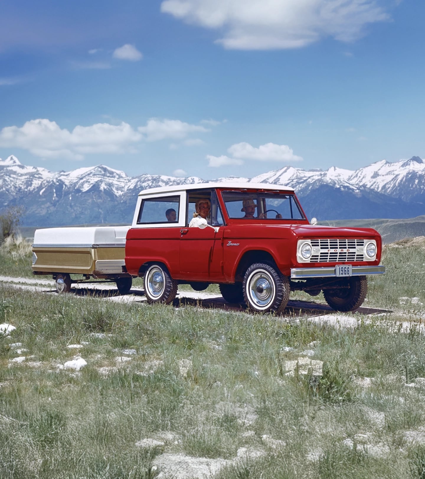 1960s Bronco wagon with a small trailer attached.