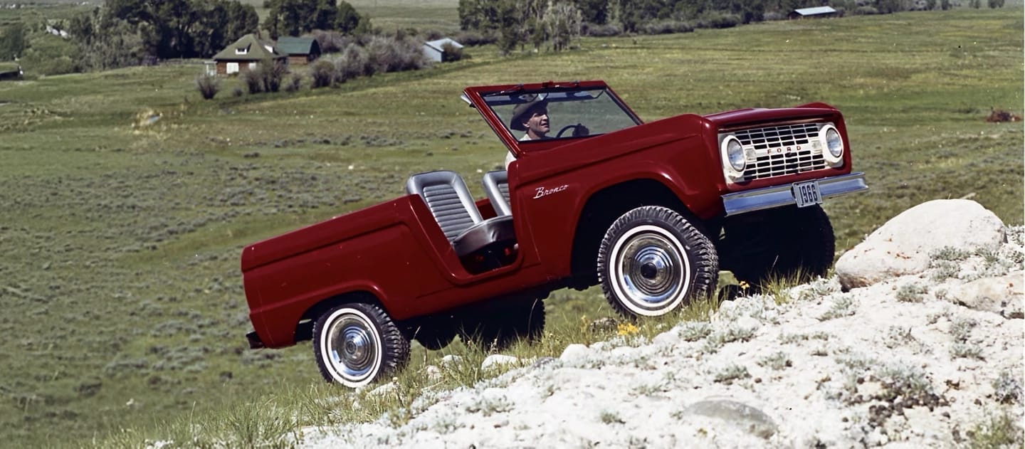 1960s Bronco Roadster driving uphill.