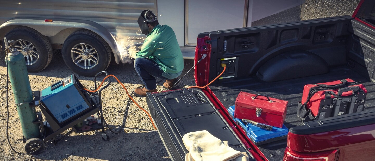 A man uses the Pro Power Onboard feature to power a welding tool plugged into an F-150.