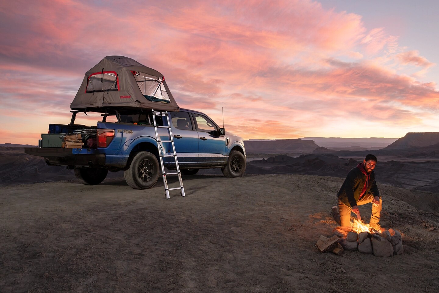 F-150 with a roof-mounted tent parked at a campsite.