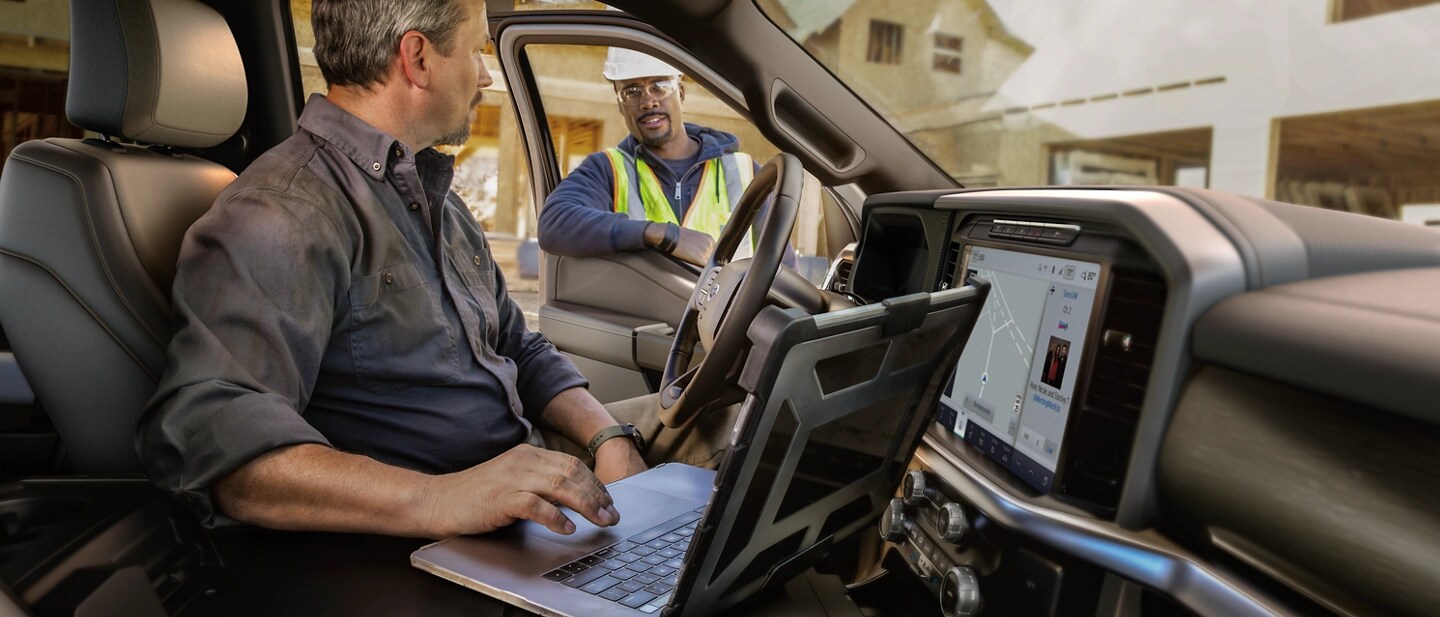 A person uses the F-150 interior flat work surface.