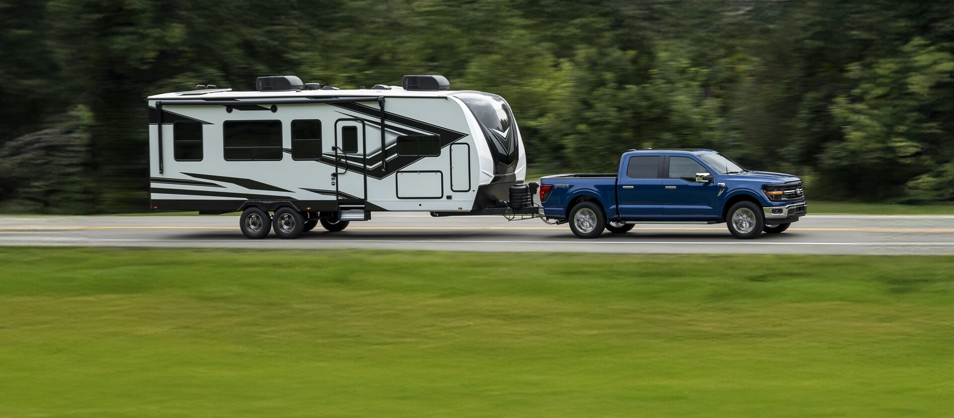 An F-150 towing a trailer on a highway.