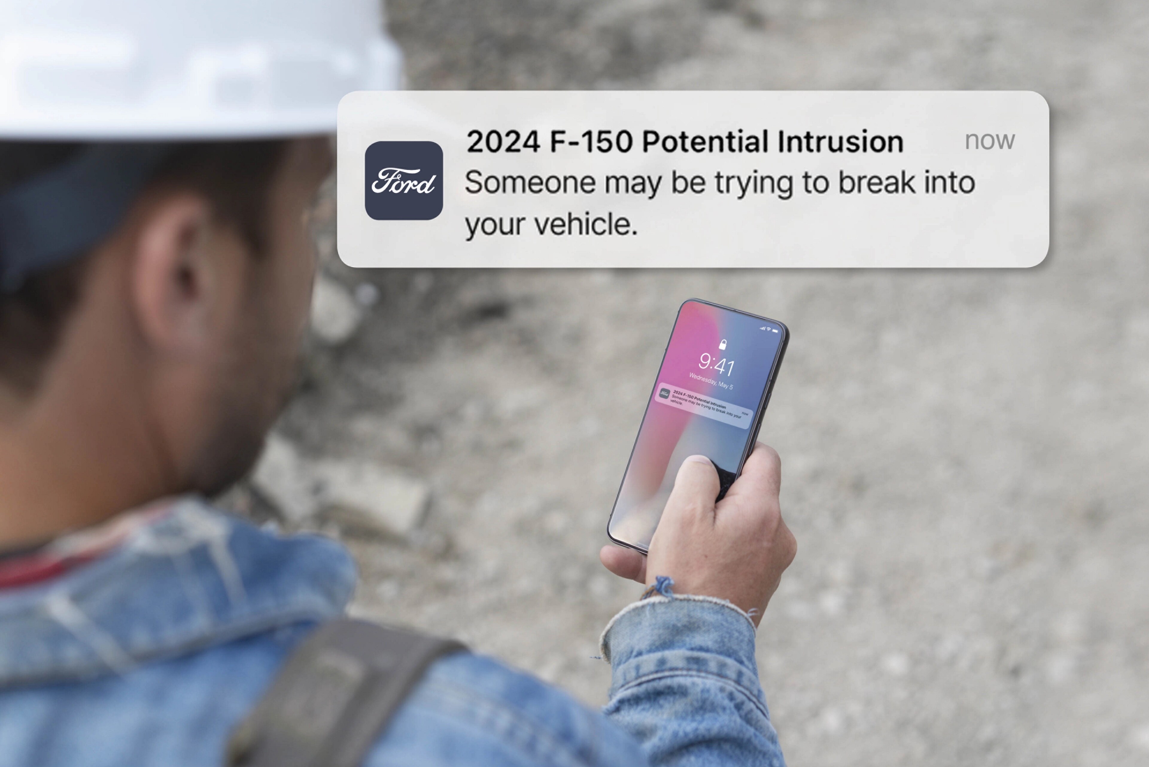 Person holding a smartphone displaying a notification. Overlay of text that reads: Potential intrusion! Someone may be trying to break into your vehicle.