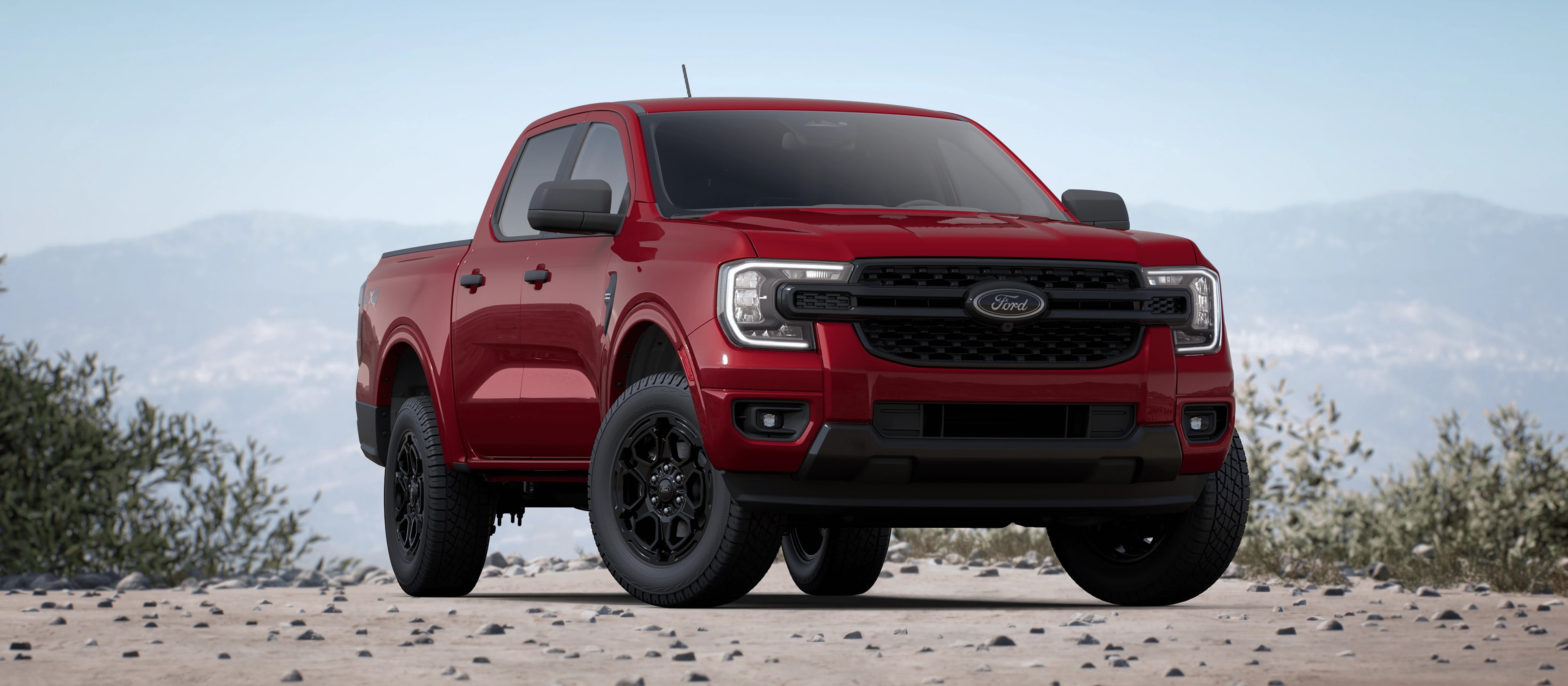 A 2025 Ford Ranger® with available Black Appearance Package parked in a field at the foot of the mountains