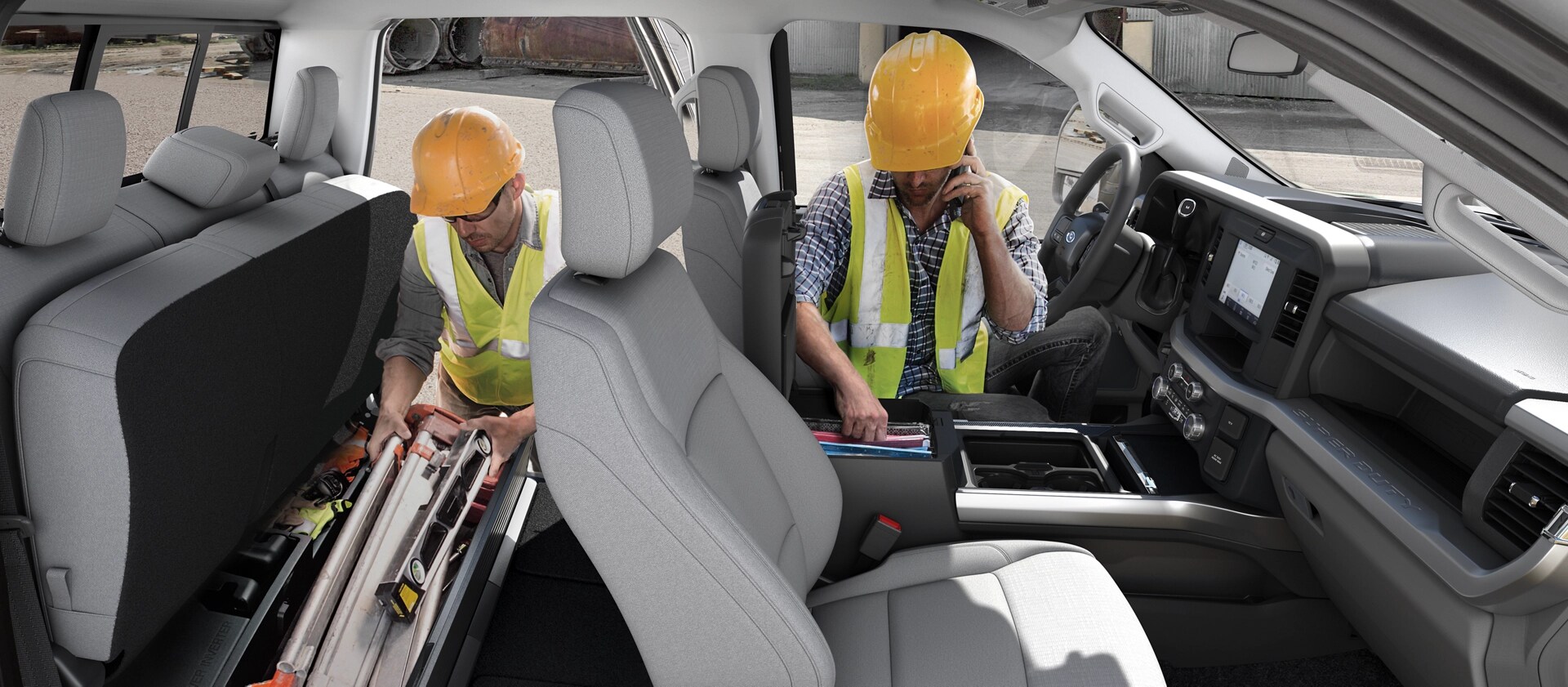 Side view of the 2026 Ford Super Duty® interior with two construction workers pulling tools out of the cabin