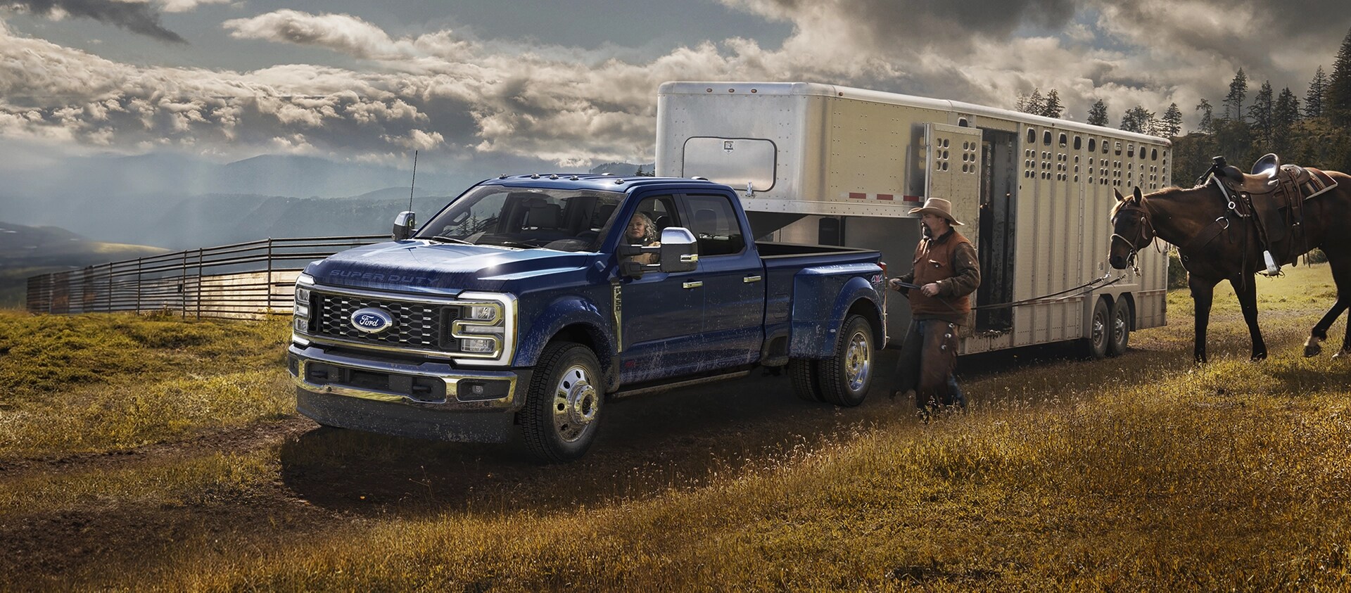 2026 Ford Super Duty® F-450® King Ranch® model in Argon Blue towing a horse carrier on a grassy farm