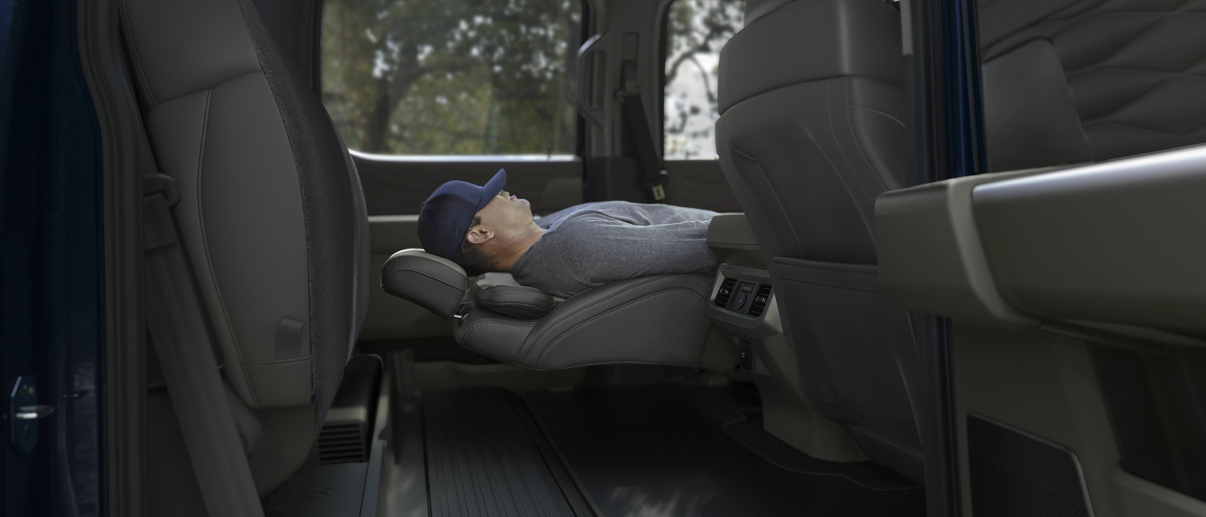Person sleeping while using the Max Recline front seats feature in their 2026 Ford Super Duty® truck
