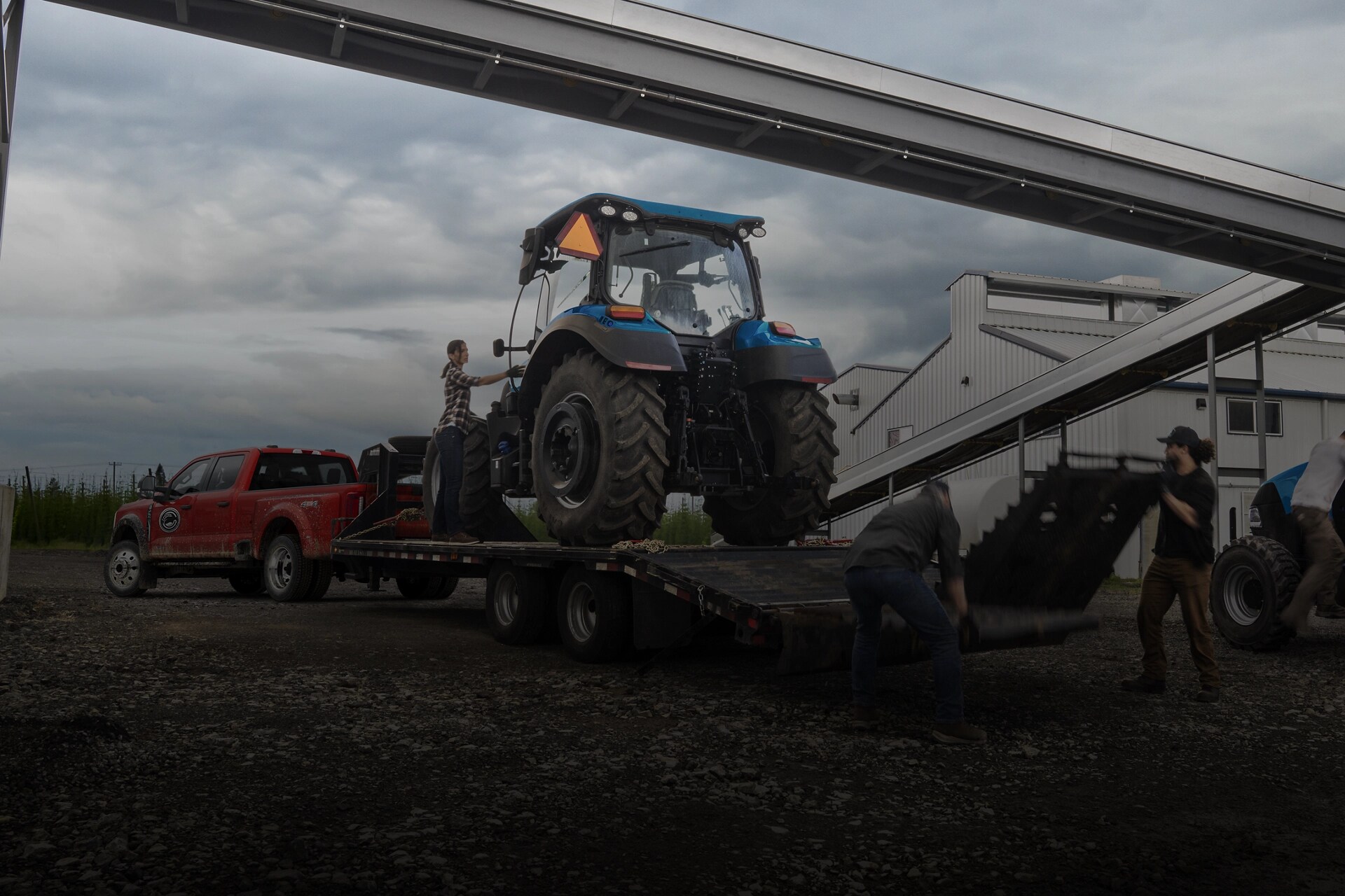 2026 Ford Super Duty® F-450® XL in Race Red pulling a trailer carrying a large tractor