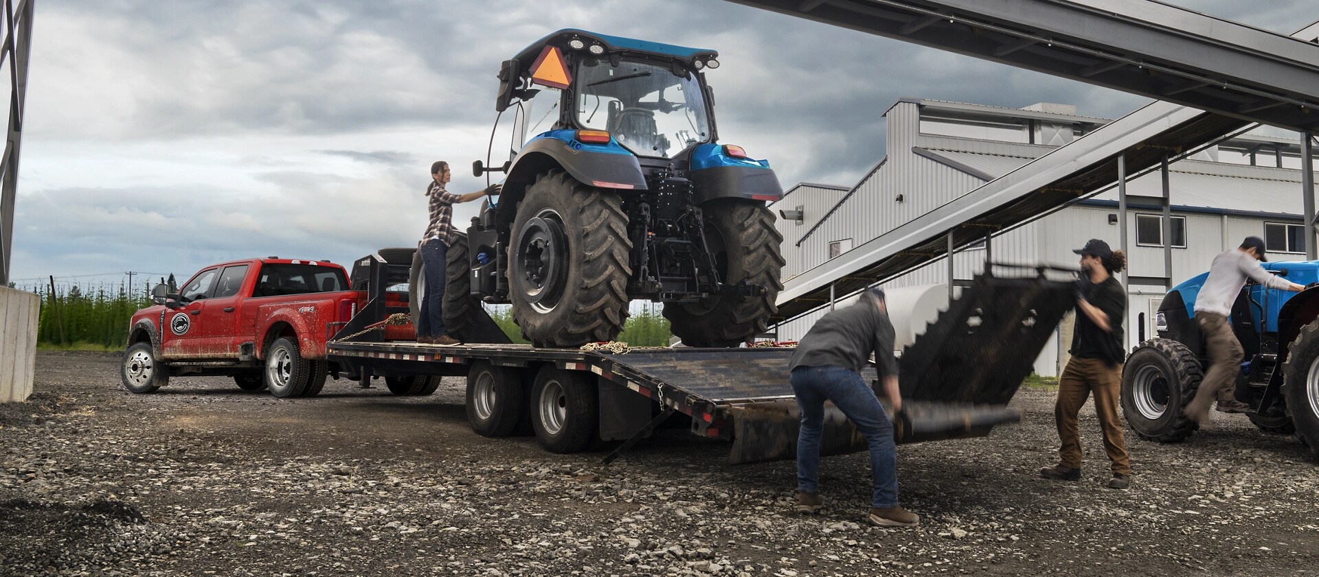 2026 Ford Super Duty® F-450® XL model in Race Red pulling a trailer with a heavy tractor on it