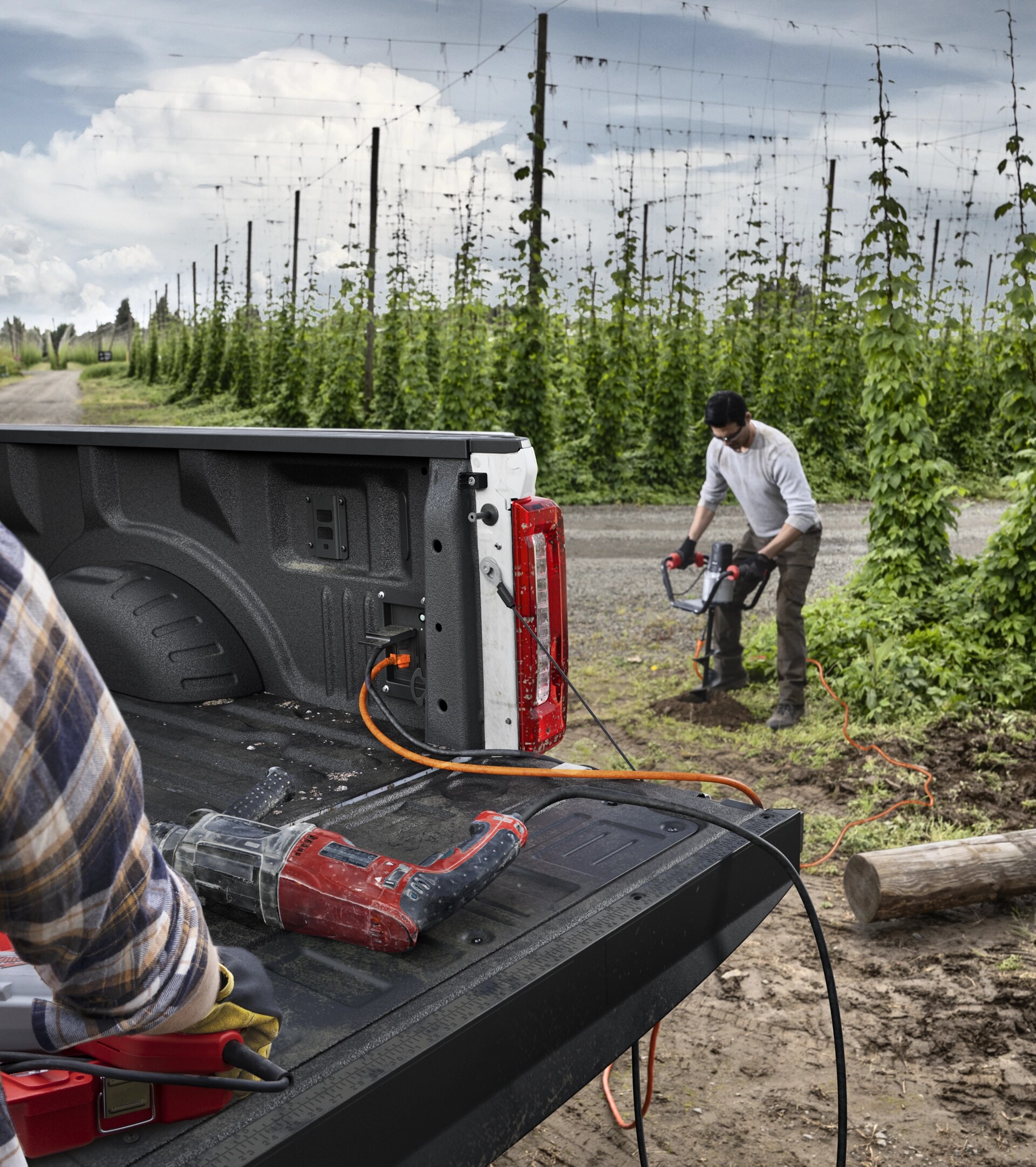 Two people with power tools using a 2026 Super Duty® F-350® XLT truck's in-bed outlets and 2kW Pro Power Onboard™ feature