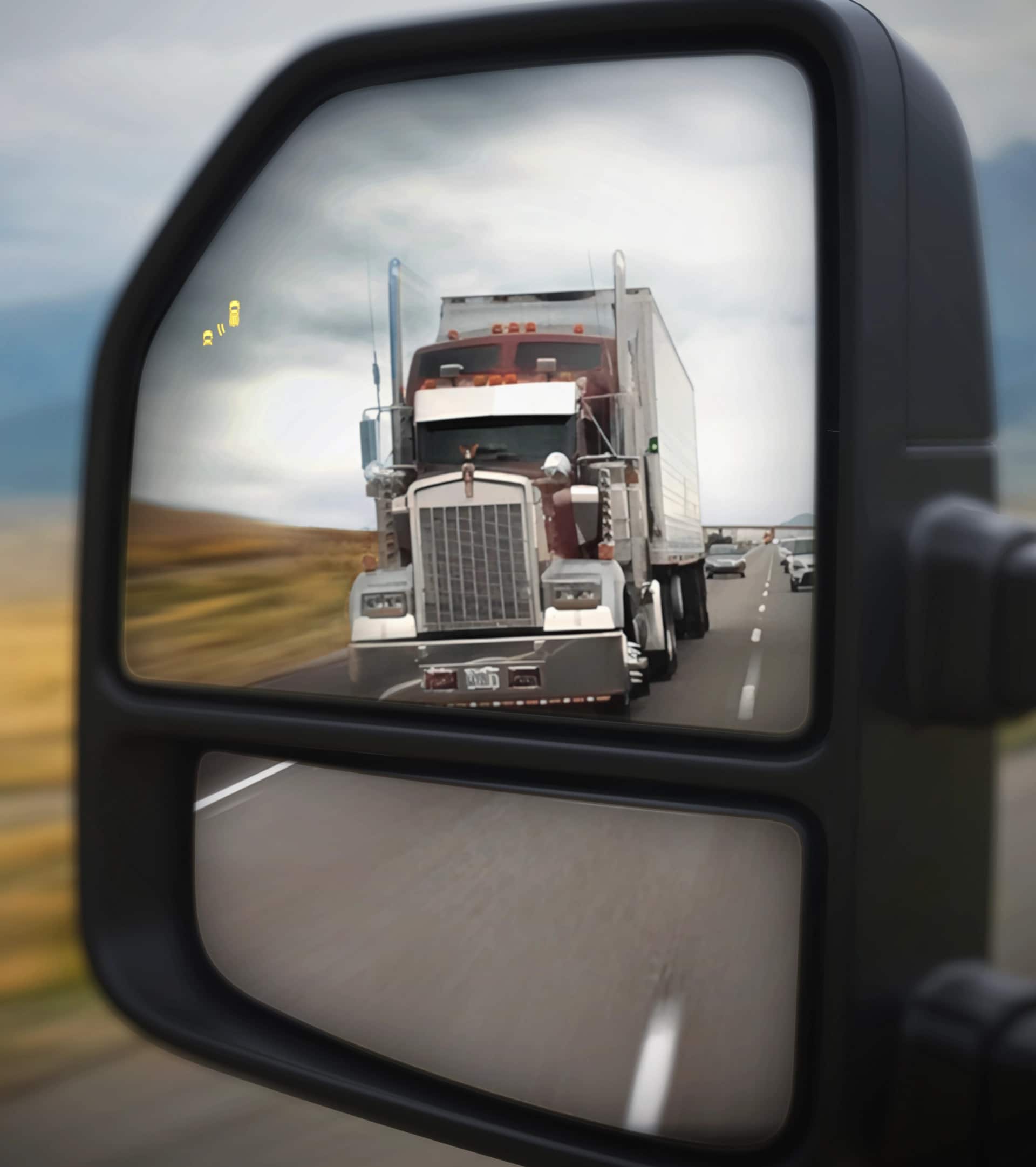 View of the 2026 Ford Super Duty® left side view mirror with a semi truck in the reflection