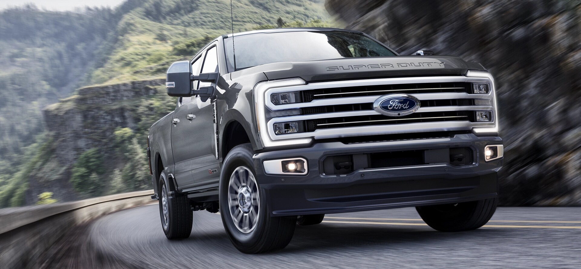 2026 Ford Super Duty® F-350® with the Platinum® Plus Package driving on a paved road in the mountains