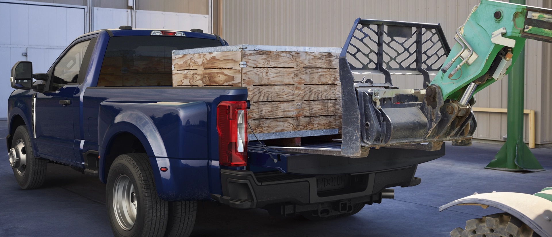 A 2026 Ford Super Duty® F-350® Lariat® model in Argon Blue with heavy crates loaded into the truck bed