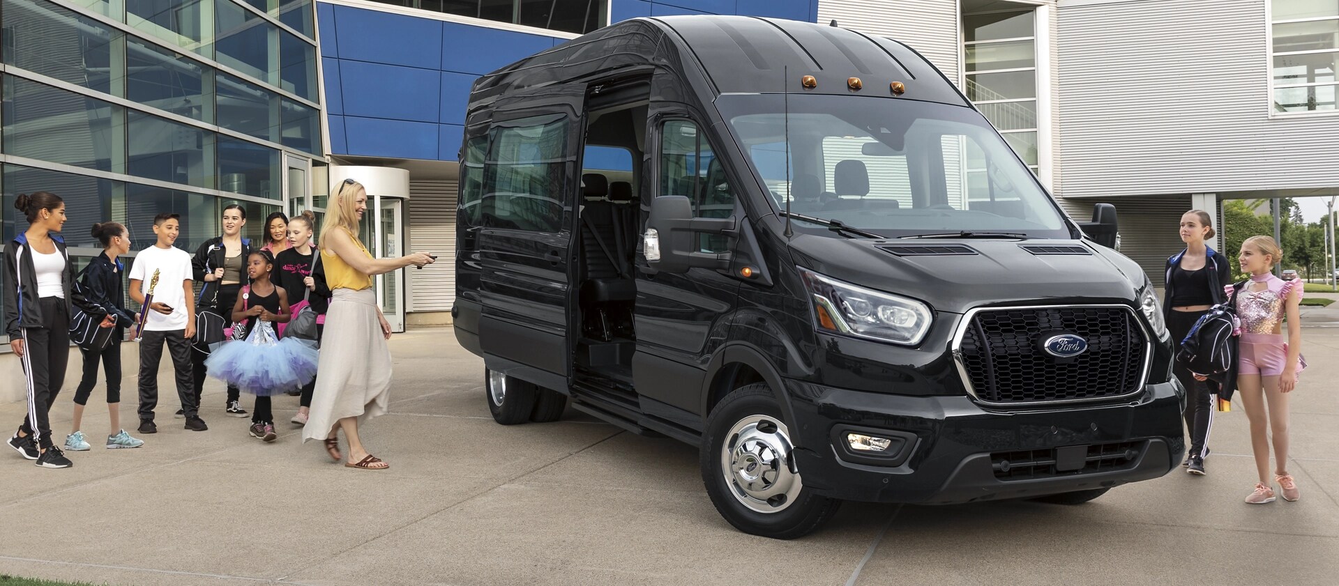 A 2025 Ford Transit® Van parked with a woman and many kids around it