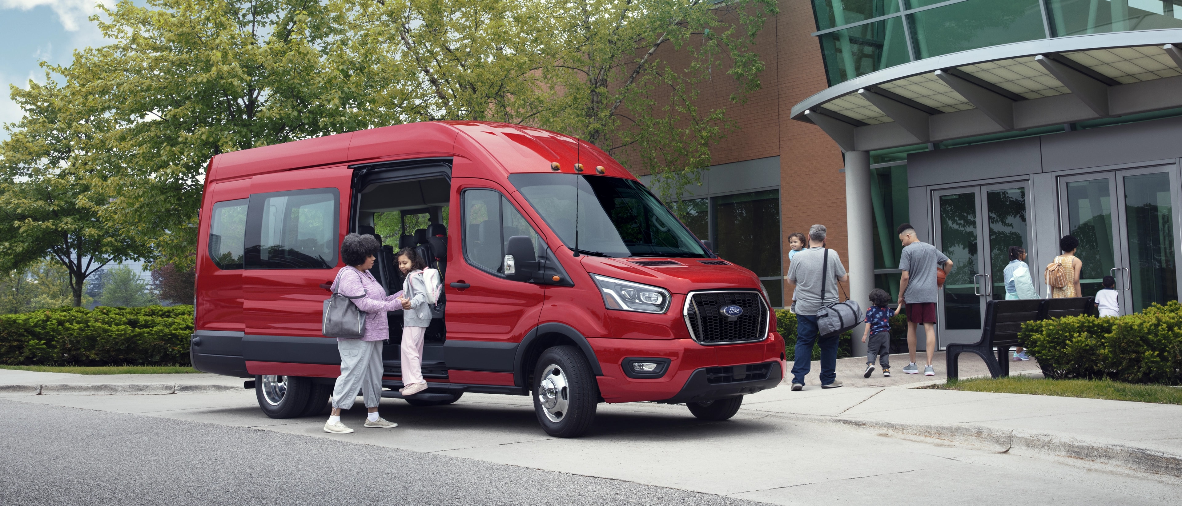 A woman helping a young girl out of a 2025 Ford Transit® van