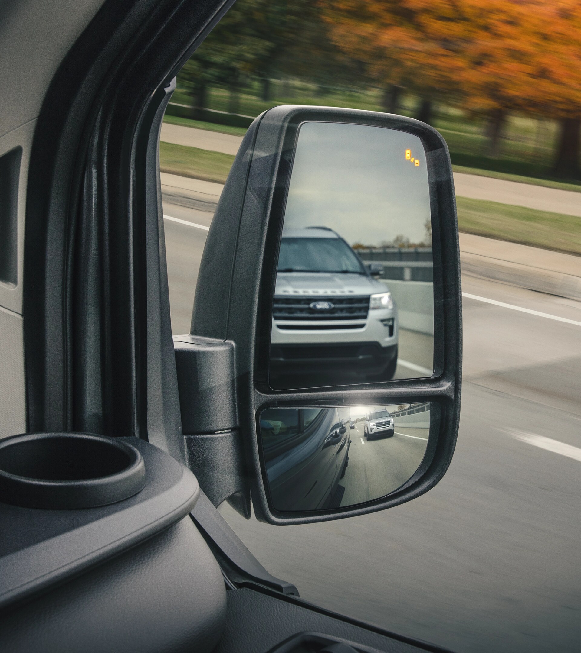 Close-up of side view mirror on a 2025 Ford Transit® Van showing vehicle blind spot