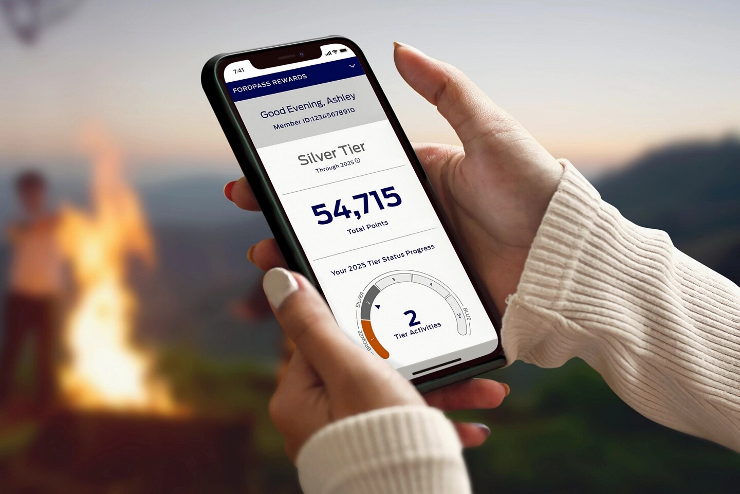 Hands are holding a smartphone and interacting with the FordPass® app