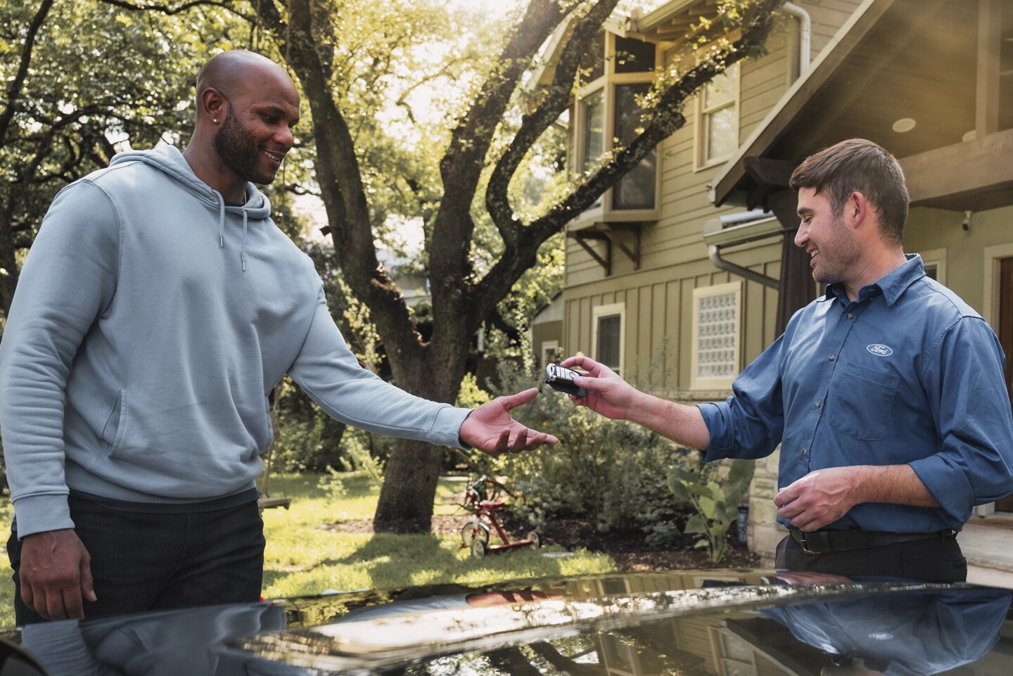 A Ford service tech hands a man his Ford key fob