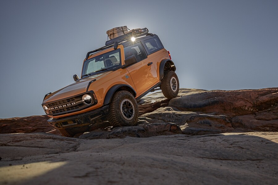 2021 Ford® Bronco™ in Cyber Orange Metallic being driven on off-road terrain