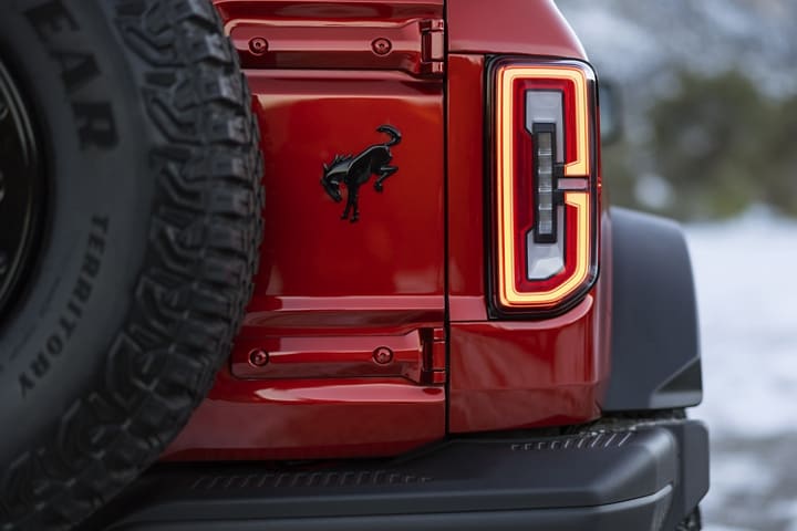 Close-up of taillamp and logo of 2023 Ford Bronco® Wildtrak™ model in Hot Pepper Red Metallic Tinted Clearcoat (Extra-Cost Colour)