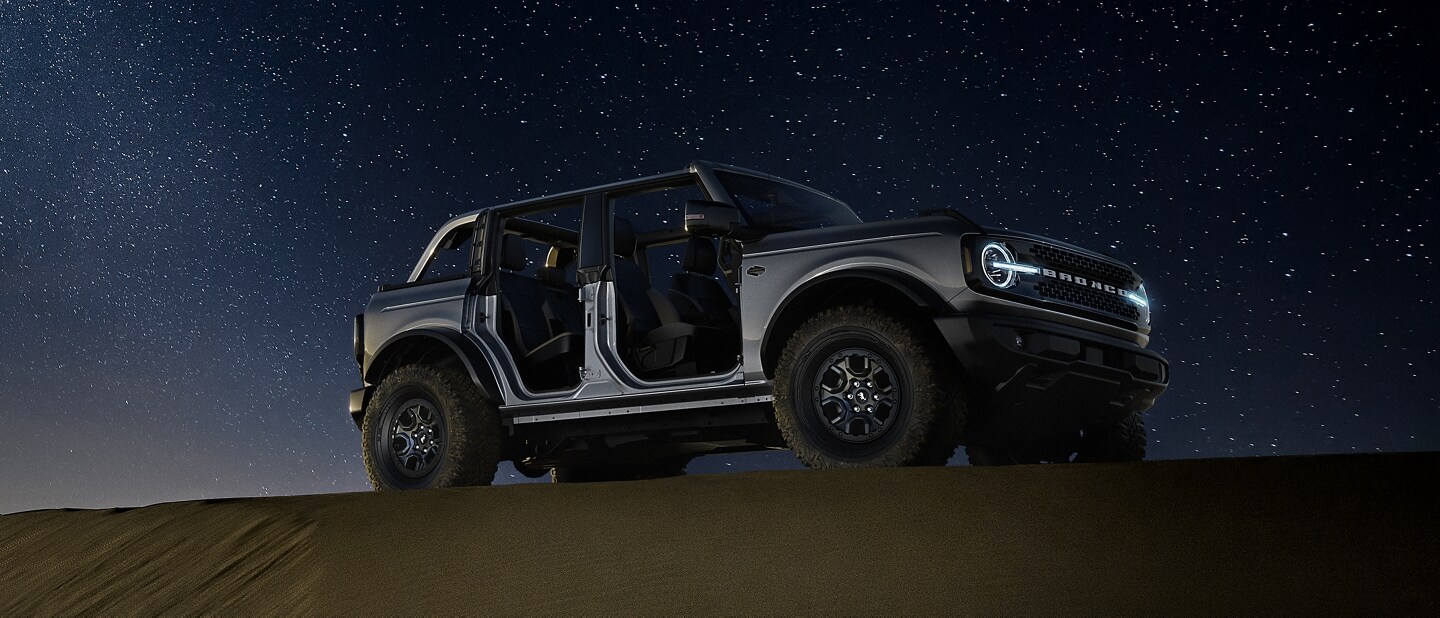 2023 Ford Bronco® Badlands™ model in Carbonized Grey Metallic parked in the wilderness at night