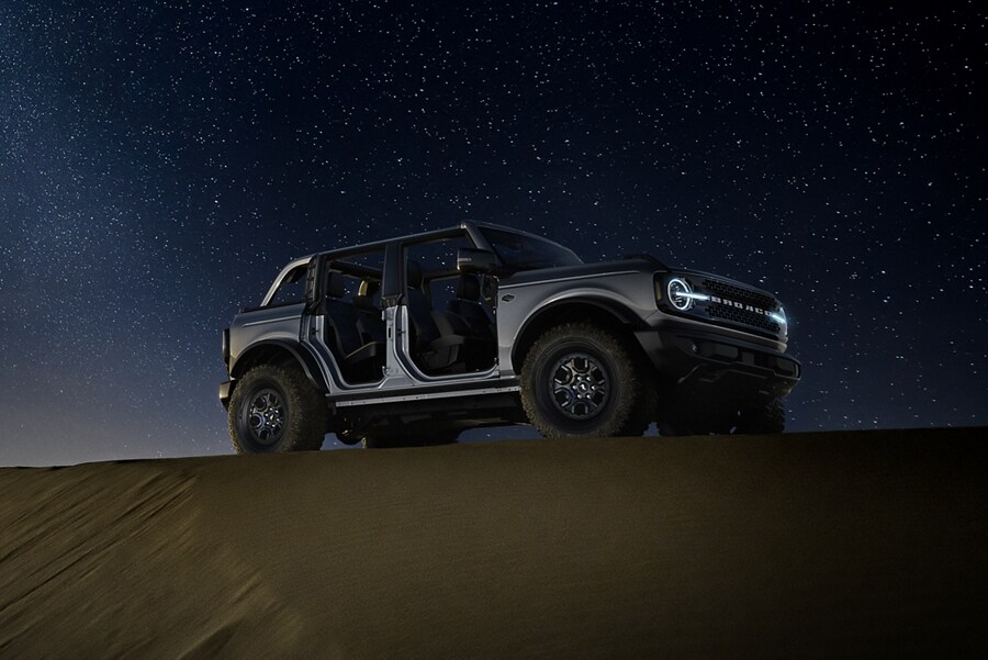 2023 Ford Bronco® Badlands™ model in Carbonized Grey Metallic parked in the wilderness at night