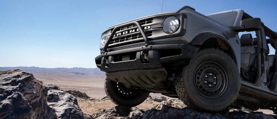 2023 Ford Bronco® Black Diamond™ in Carbonized Grey Metallic being driven over rough terrain