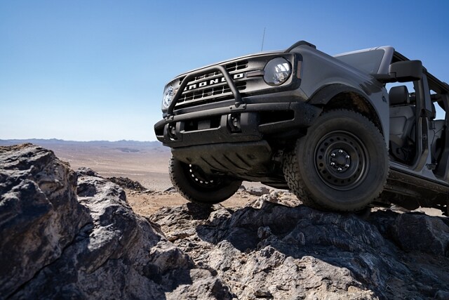 2023 Ford Bronco® Black Diamond™ in Carbonized Grey Metallic being driven over rough terrain