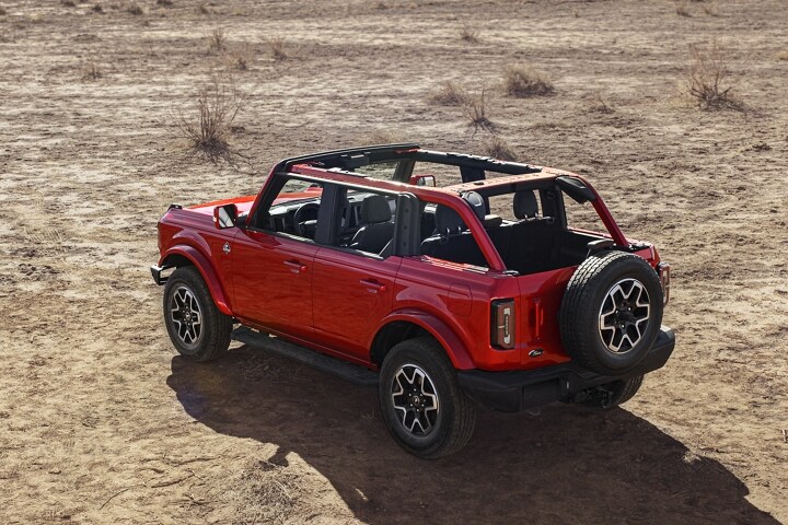 4-door 2023 Ford Bronco® Outer Banks™ model in Hot Pepper Red Metallic Tinted Clearcoat parked in the desert