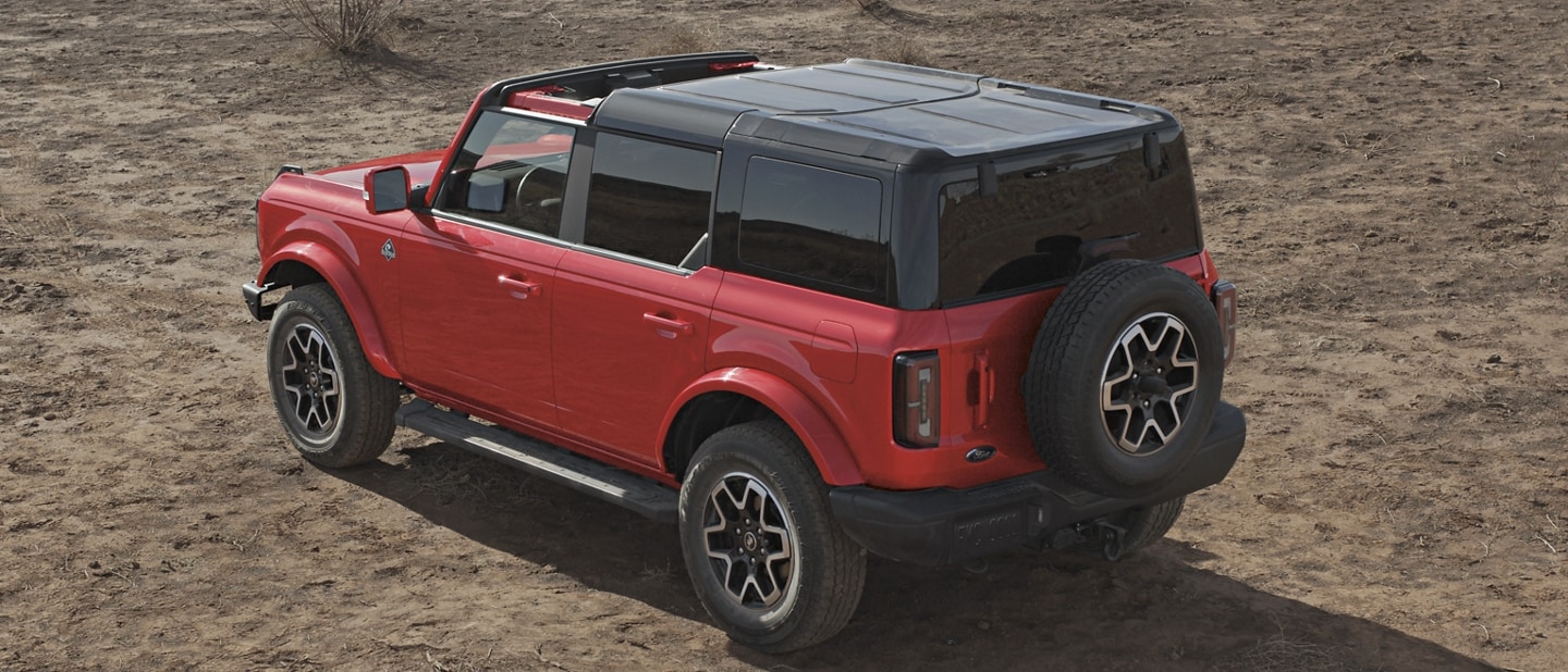 4-door 2023 Ford Bronco® Outer Banks™ model shown in Race Red with hardtop partially removed
