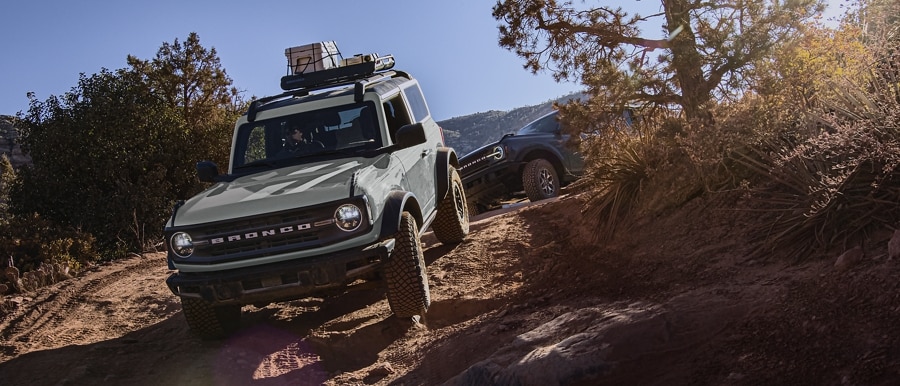 2023 Ford Bronco® Black Diamond™ in Cactus Grey being driven on a trail with another Bronco® behind