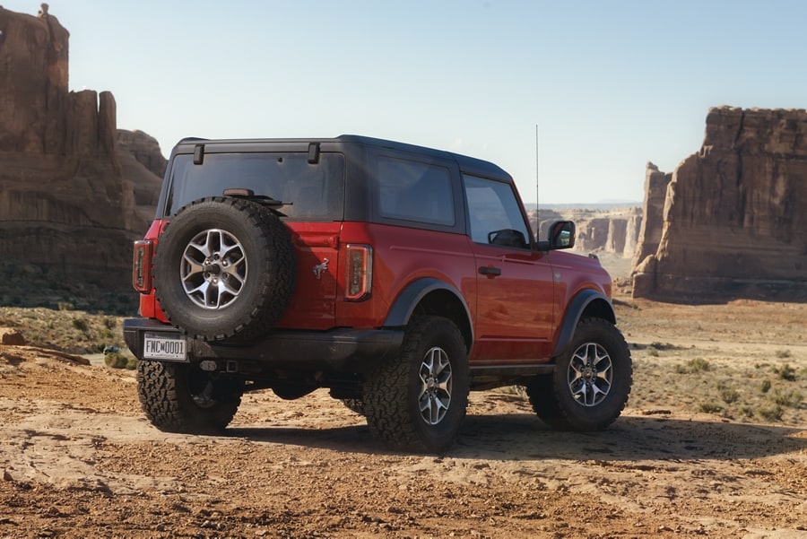2-door 2024 Ford Bronco® Badlands™ model in Race Red parked in the desert