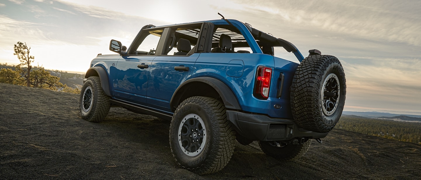 A 2024 Ford Bronco® 4-door SUV in Velocity Blue Metallic parked on a scenic overlook