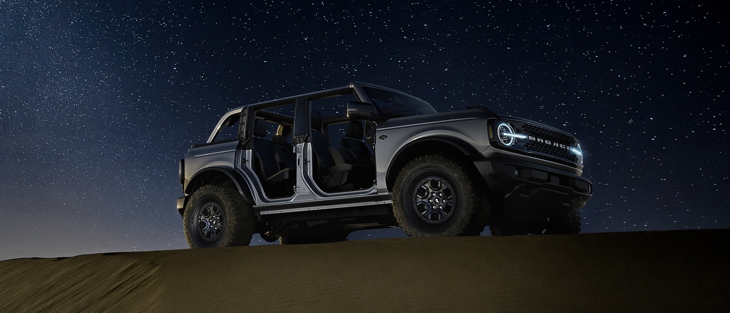 2024 Ford Bronco® Badlands™ model in Carbonized Grey Metallic parked in the wilderness at night