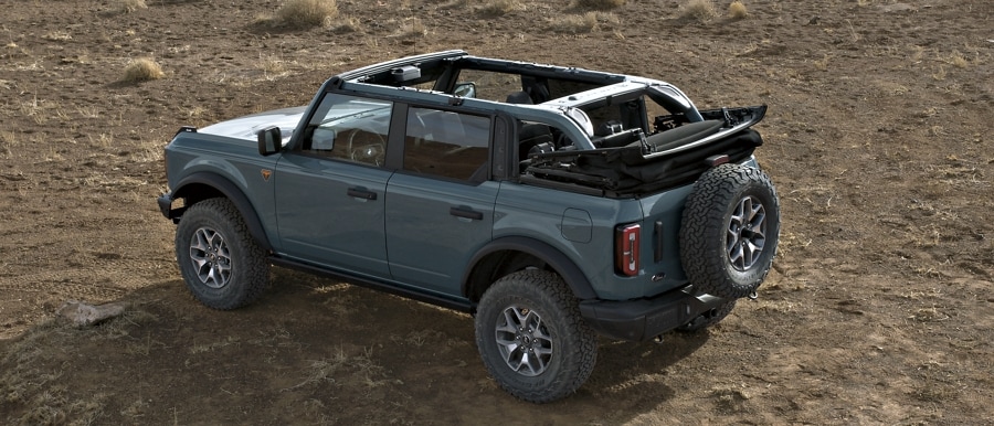 4-door 2024 Ford Bronco® Badlands™ model shown in Azure Grey Metallic Tri-Coat with soft top roof fully open