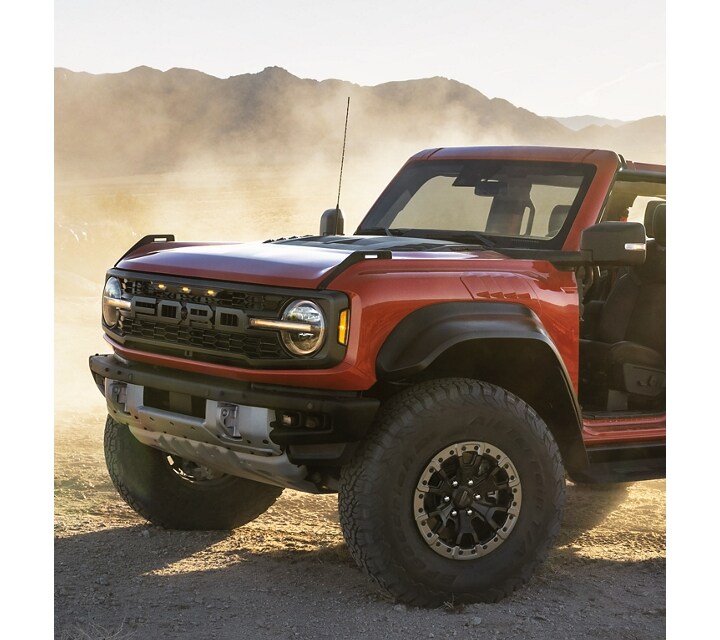 2024 Ford Bronco® Raptor® model in Hot Pepper Red Metallic driving off-road