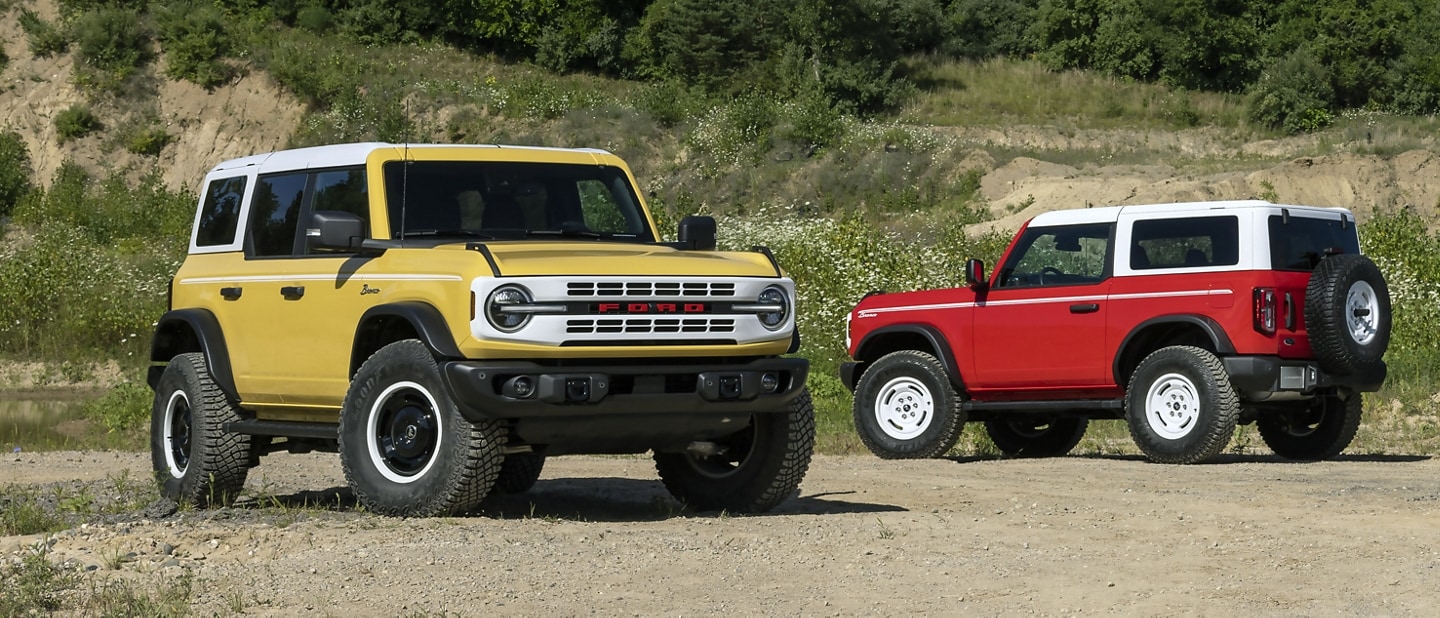 Two 2024 Ford Bronco® Heritage Editions parked in a clearing