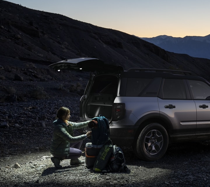 2023 Ford Bronco® Sport SUV parked at night with tailgate open and lighting the ground