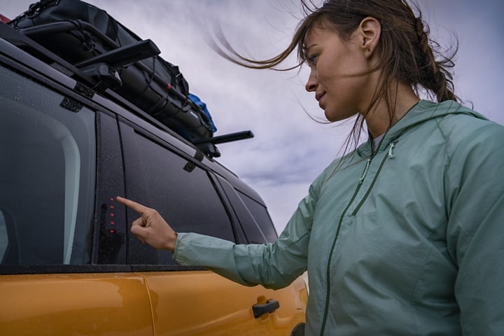 Woman pushing keypad while standing outside of her 2023 Ford Bronco® Sport SUV