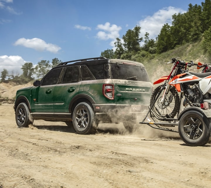 A 2023 Ford Bronco® Sport SUV towing two dirt bikes off road